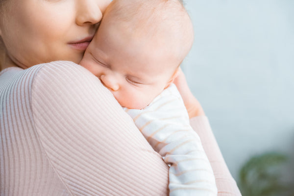 Young Mother Carrying Adorable Sleeping Baby