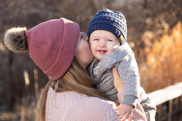 mother kissing a baby wearing KeaBabies Baby Beanie, Winter clothes