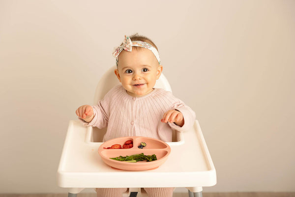 baby having a meal on a high chair