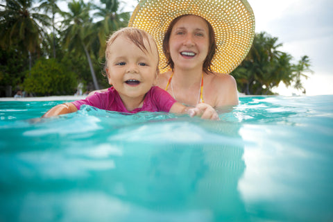 Kid swimming with mothers help
