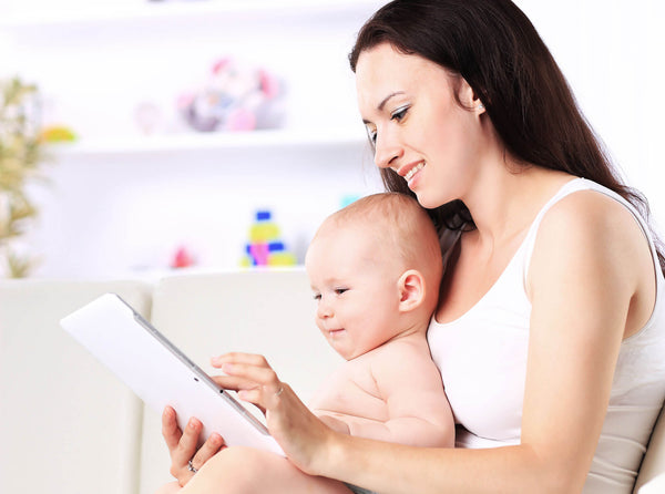 Mother and baby child are looking to play  read tablet computer