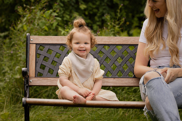 smiling baby at a park bench