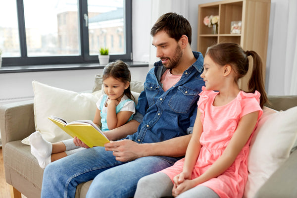 father reading with daughters