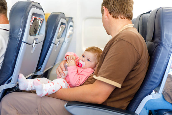 Father holding his baby daughter during flight on airplane