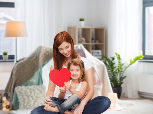 Happy mother with adorable little girl and heart