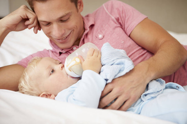 Father Giving Daughter Bottle Of Milk