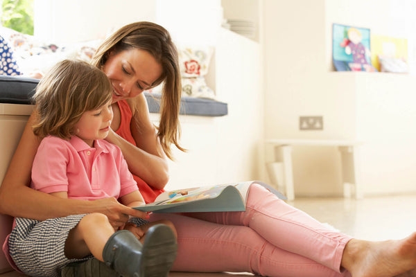 Mother Sitting With Son Reading Story Indoors