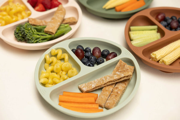 healthy food on divided silicone plates