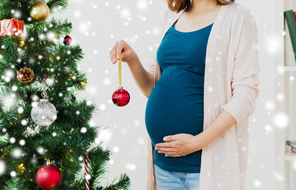 Pregnant woman decorating Christmas tree
