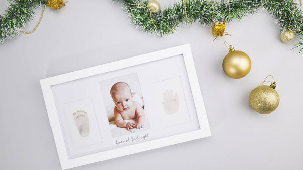 A baby's photograph at the center of KeaBabies Duo Keepsake Frame with handprint and footprint on the sides