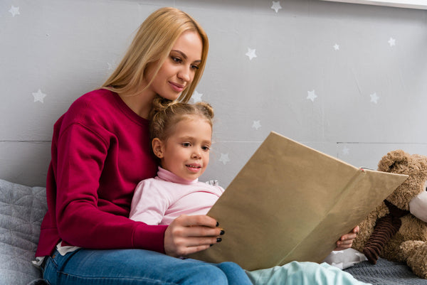 Young Mother Daughter Sitting Bed Reading Book Together
