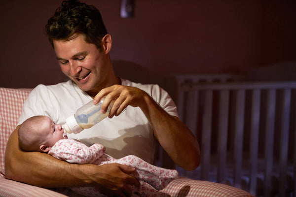 father feeding baby before bedtime