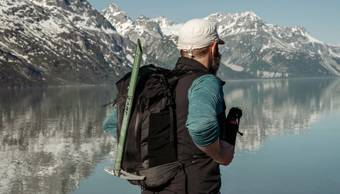 man standing near a mountain lake