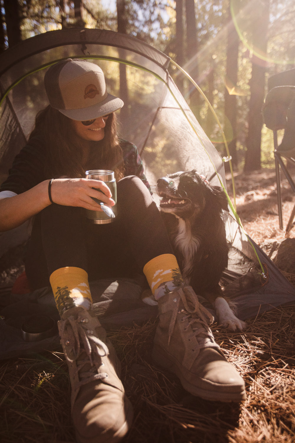 woman sitting near her tent with her pup