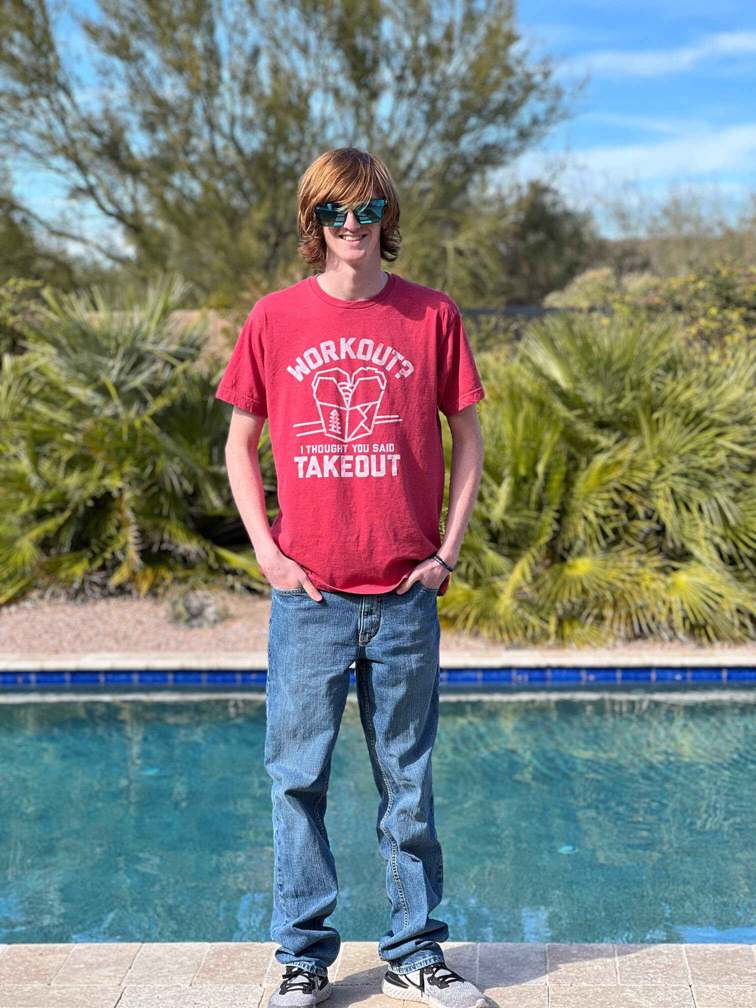 young man wearing sunglasses by a pool