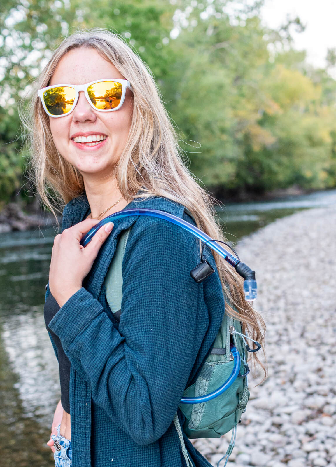 woman smiling near a river