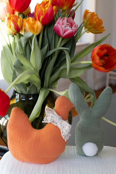 Stuffed rabbit and stuffed hen in front of tulips