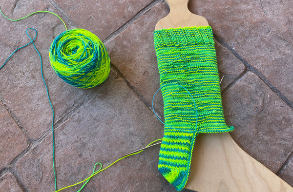 sock being knitted on sock blocker 