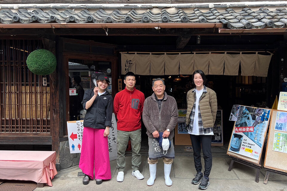 Rina, toji Ryuichi Yoshida, Kazukiyo Minematsu and Azusa stand outside of the brewery shop