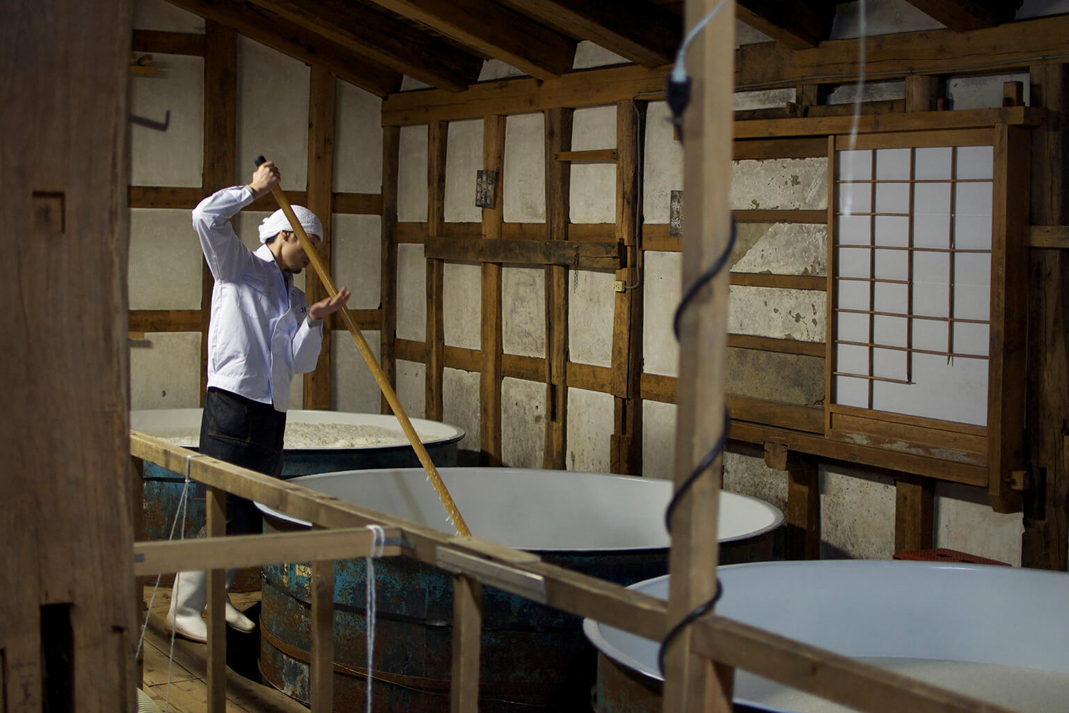 A “kurabito” (brewery worker) mixes the sake mash