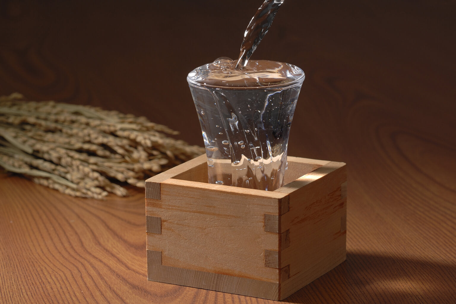 Sake is poured “mokkiri” style, overflowing into the wooden “masu”
