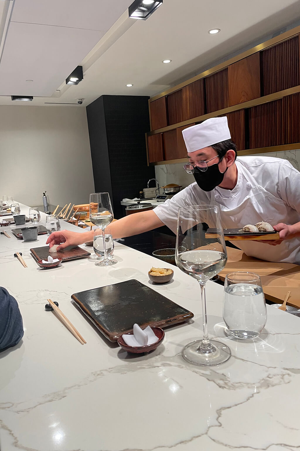 The chef serves a sushi over the counter.