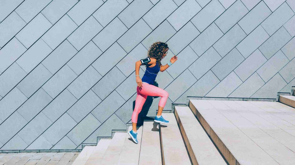 A woman jogging up some stairs outdoors. Concept of exercising regularly. 