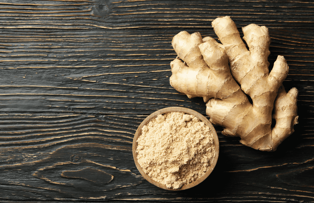 Ginger roots and a bowl of ginger powder. 
