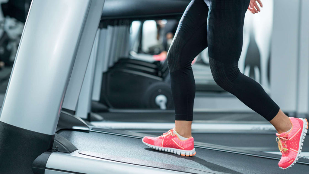 A woman incline walking on a treadmill.