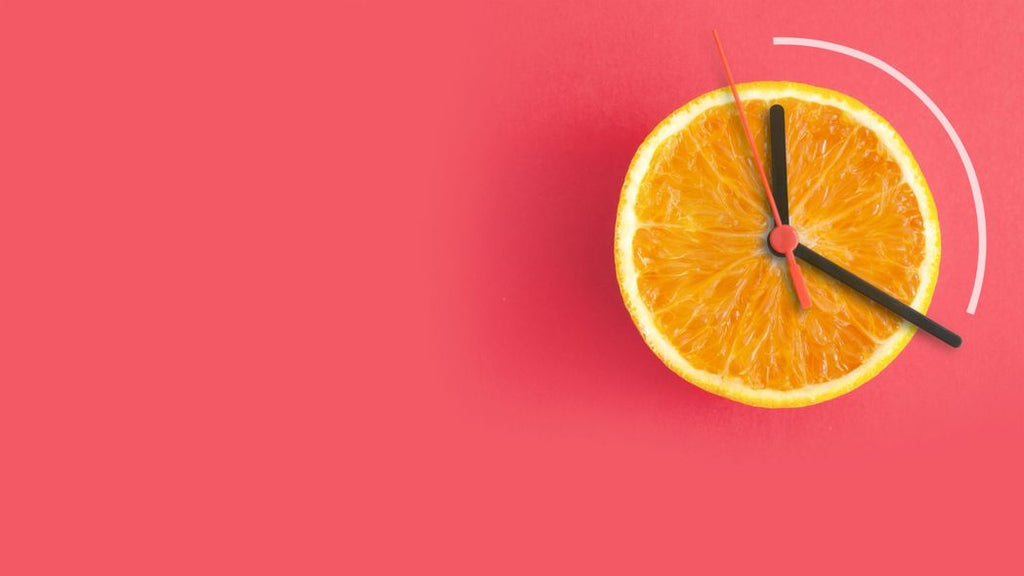 Concept of intermittent fasting represented by a lemon slice made to look like a clock. 