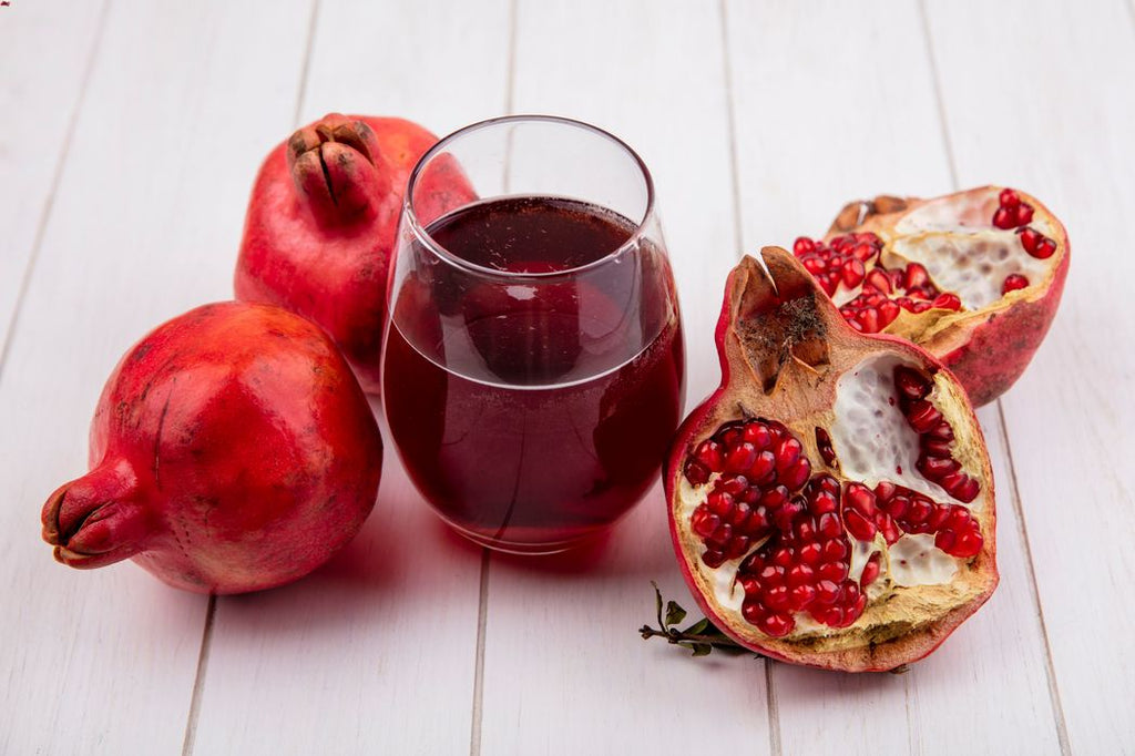 Pomegranates and pomegranate juice against a white backdrop.