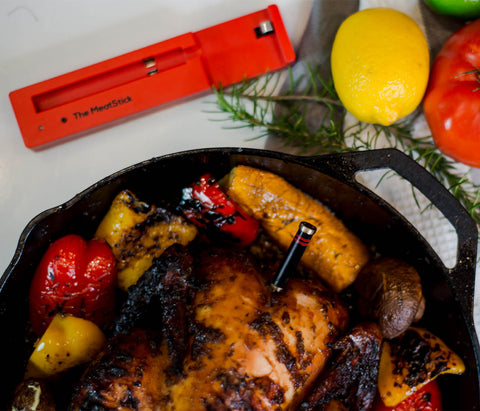 The MeatStick and whole grilled jerk chicken with assorted veggies in a pan