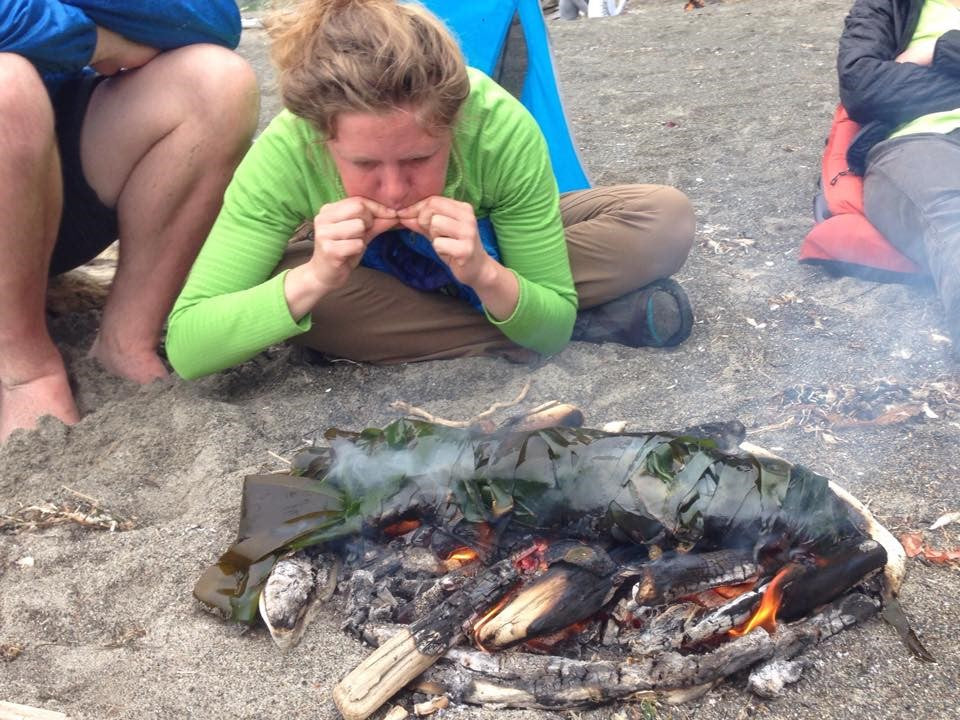 Michelle Learned stoking coals for fire roasted salmon