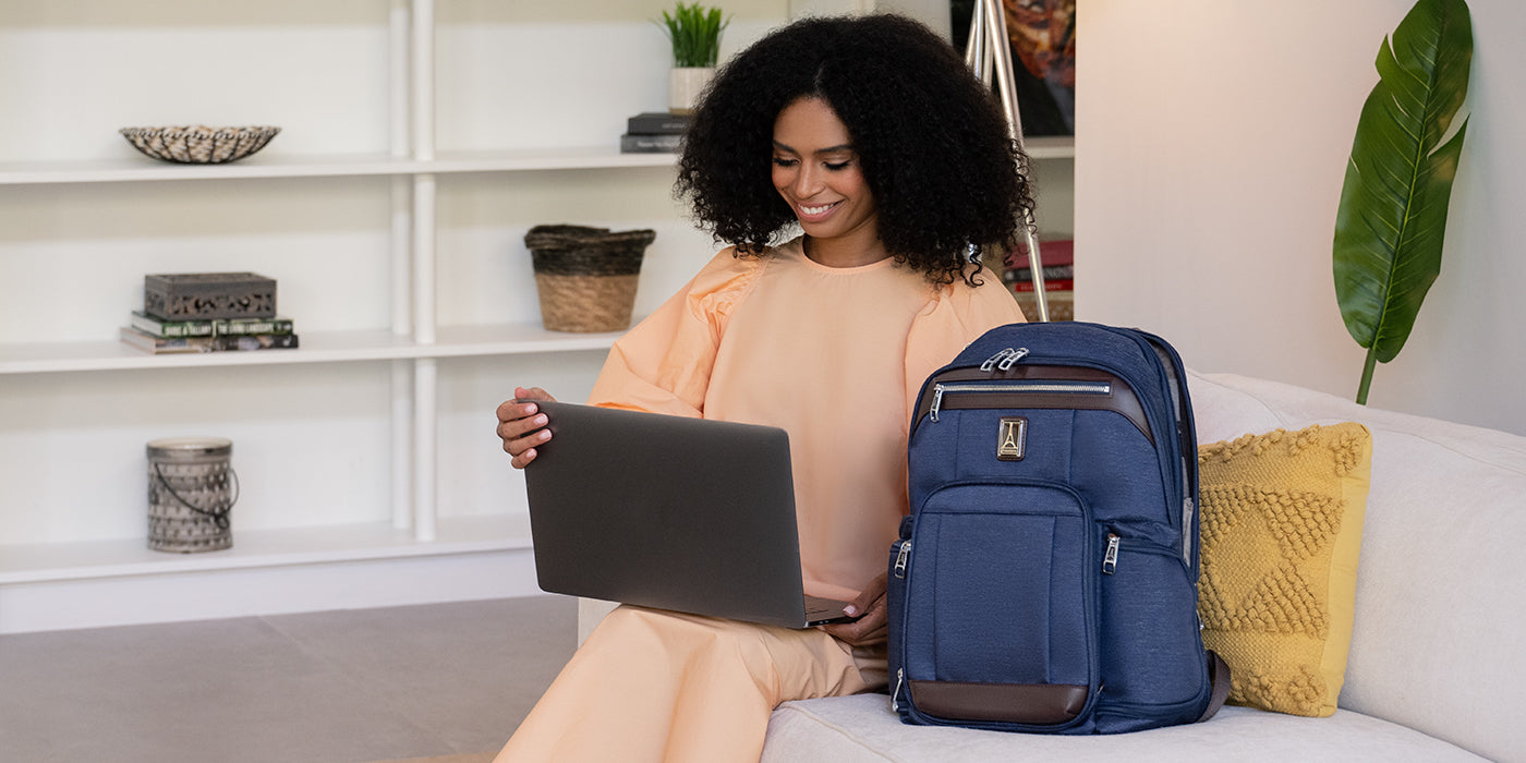 
Woman with laptop on lap with backpack next to her on the couch