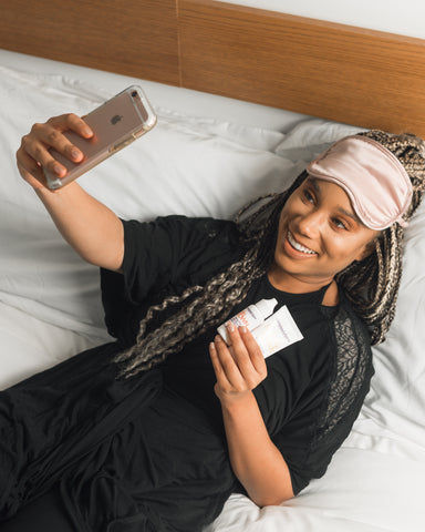 woman taking a selfie with beauty products