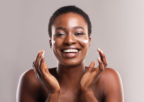 Black woman applying face cream