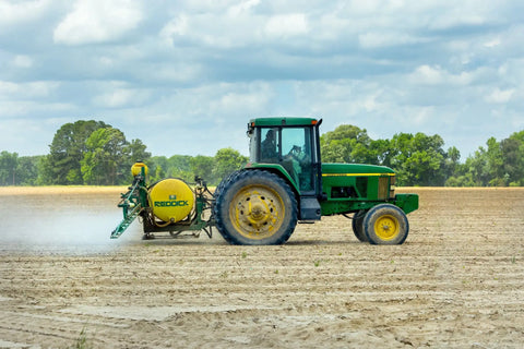 tractor spraying chemicals on land