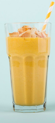orange smoothie in glass cup on blue background
