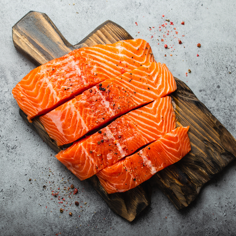 salmon with seasoning on a wooden board