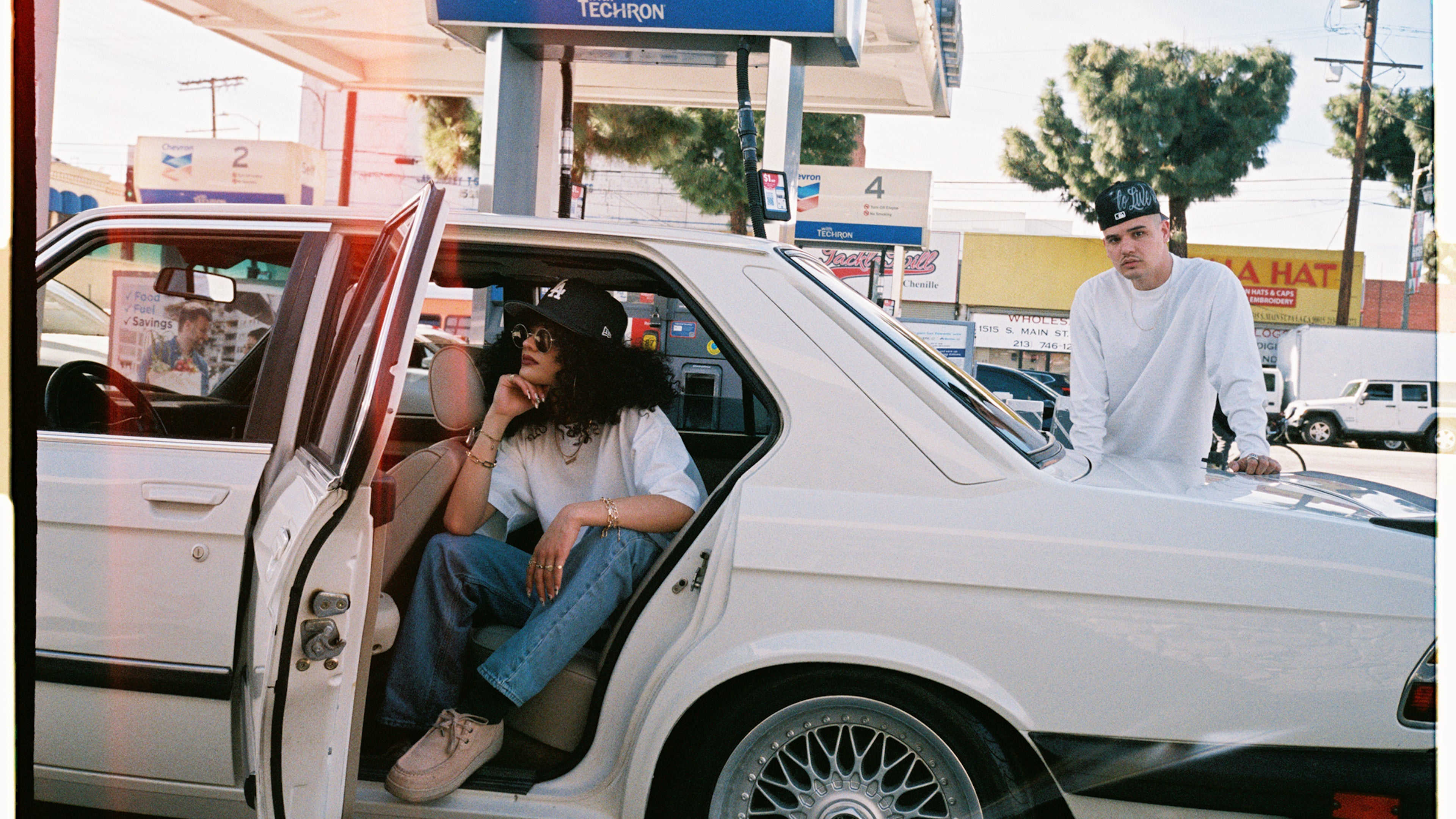 WHITE T SHIRT, FASHION, BLANKS , WHITE BMW AT A GAS STATION A MAN WEARING A WHITE T SHIRT IS PUMPING GAS WHILE AN ATTRACTIVE LADY IS ALSO WEARING A WHITE T SHIRT SITS IN THE CAR POSING