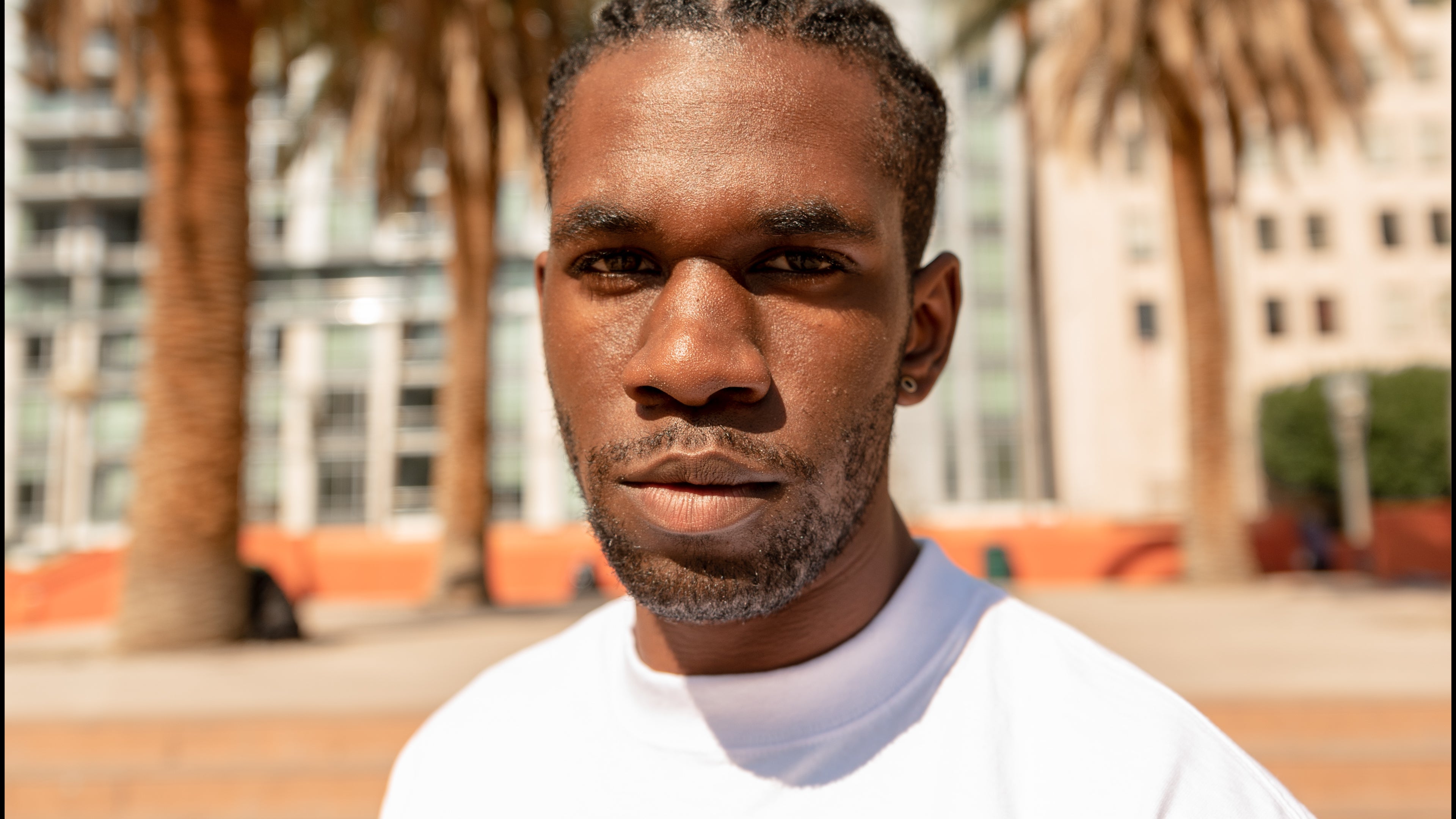 An African American Male stares into the camera wearing a Shaka Wear T shirt 