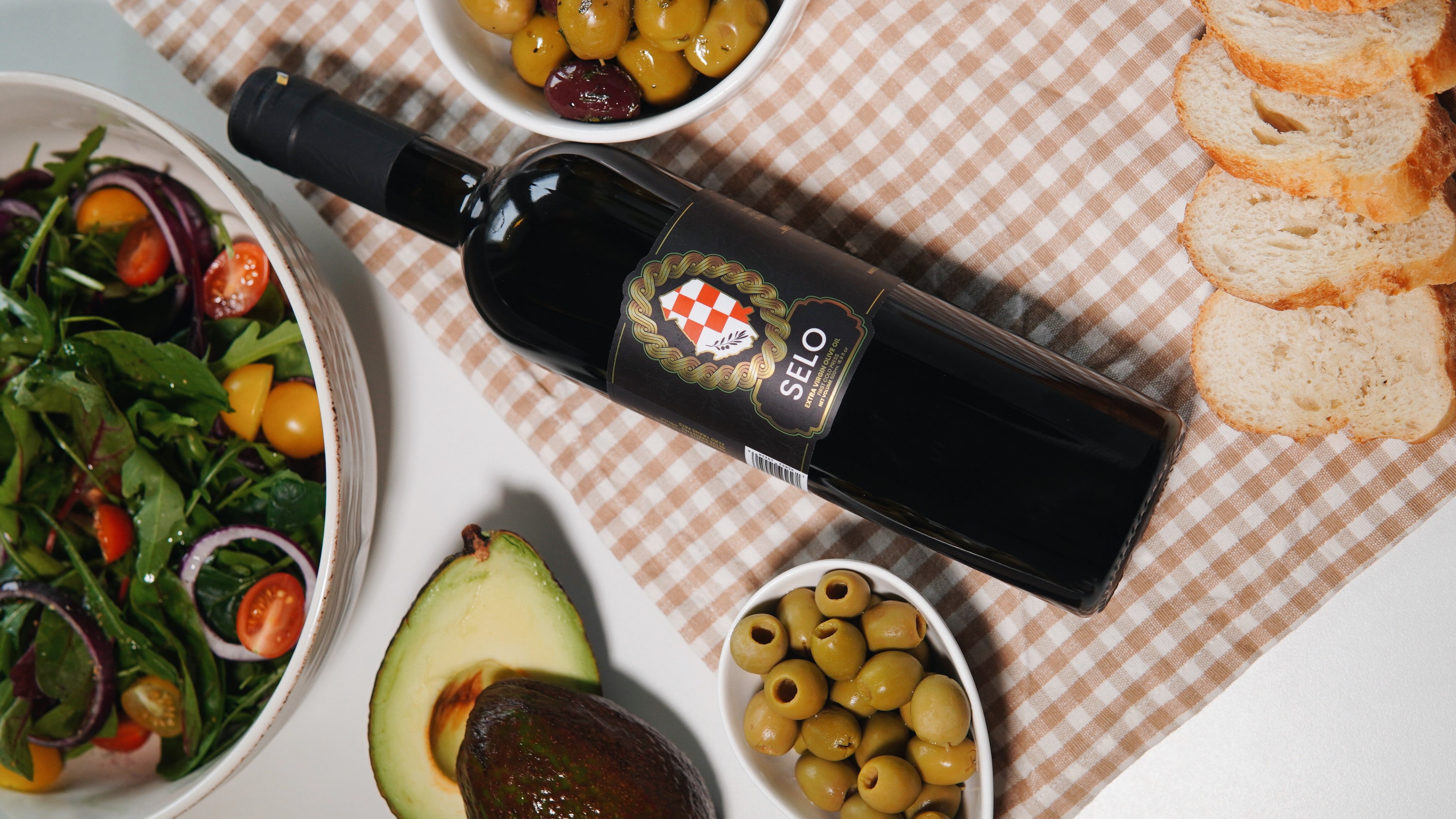 A bottle of Selo Croatian Extra Virgin Olive Oil on a rustic wooden table, embodying a staple ingredient for a nutritious keto diet.