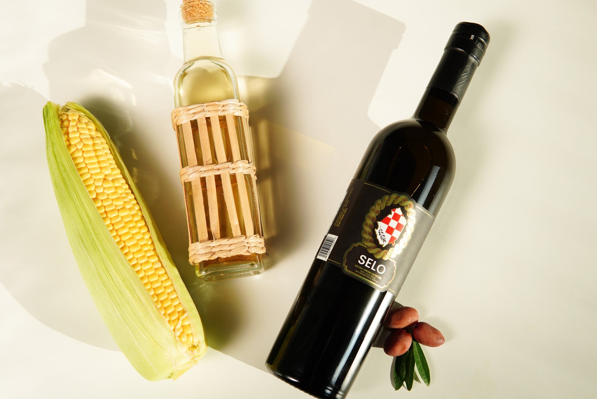 A single bottle of Selo olive oil next to a bottle of palm oil, highlighting the choice for healthier cooking.