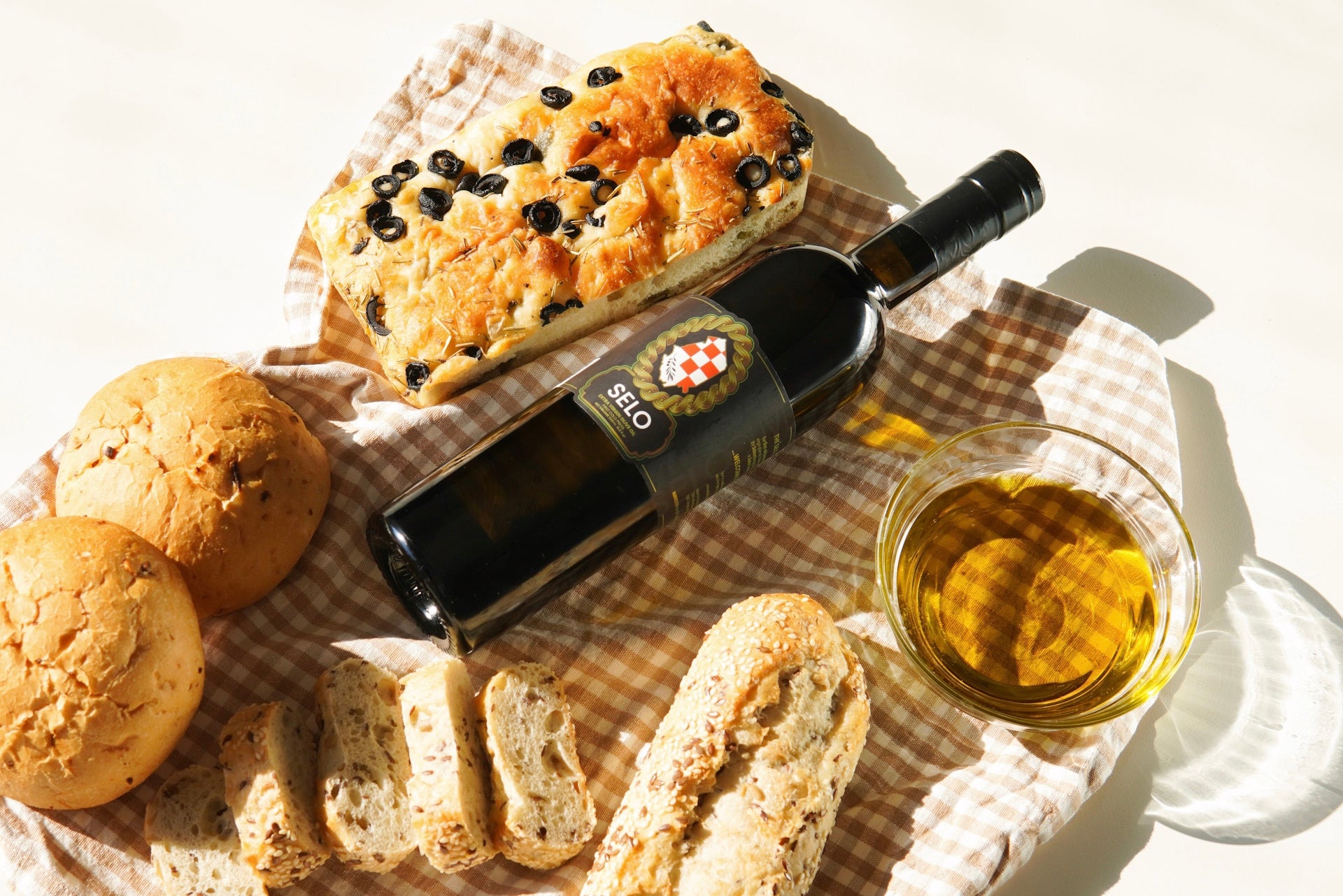Freshly baked breads glistening with Selo extra virgin olive oil, a golden touch of perfection.