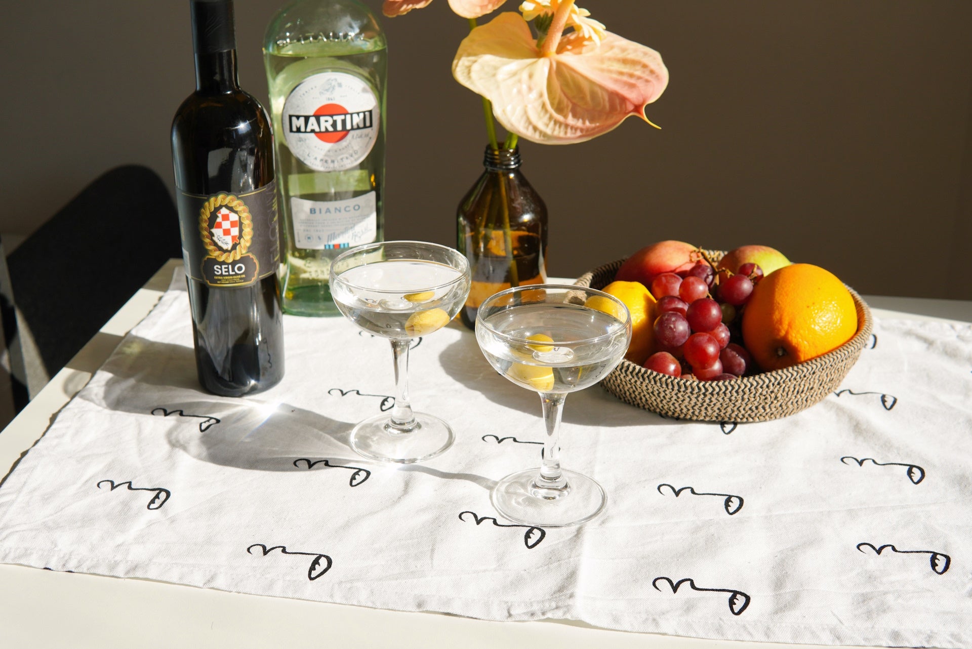 Martini glass with Selo Croatian olive oil glistening, placed on a kitchen table.