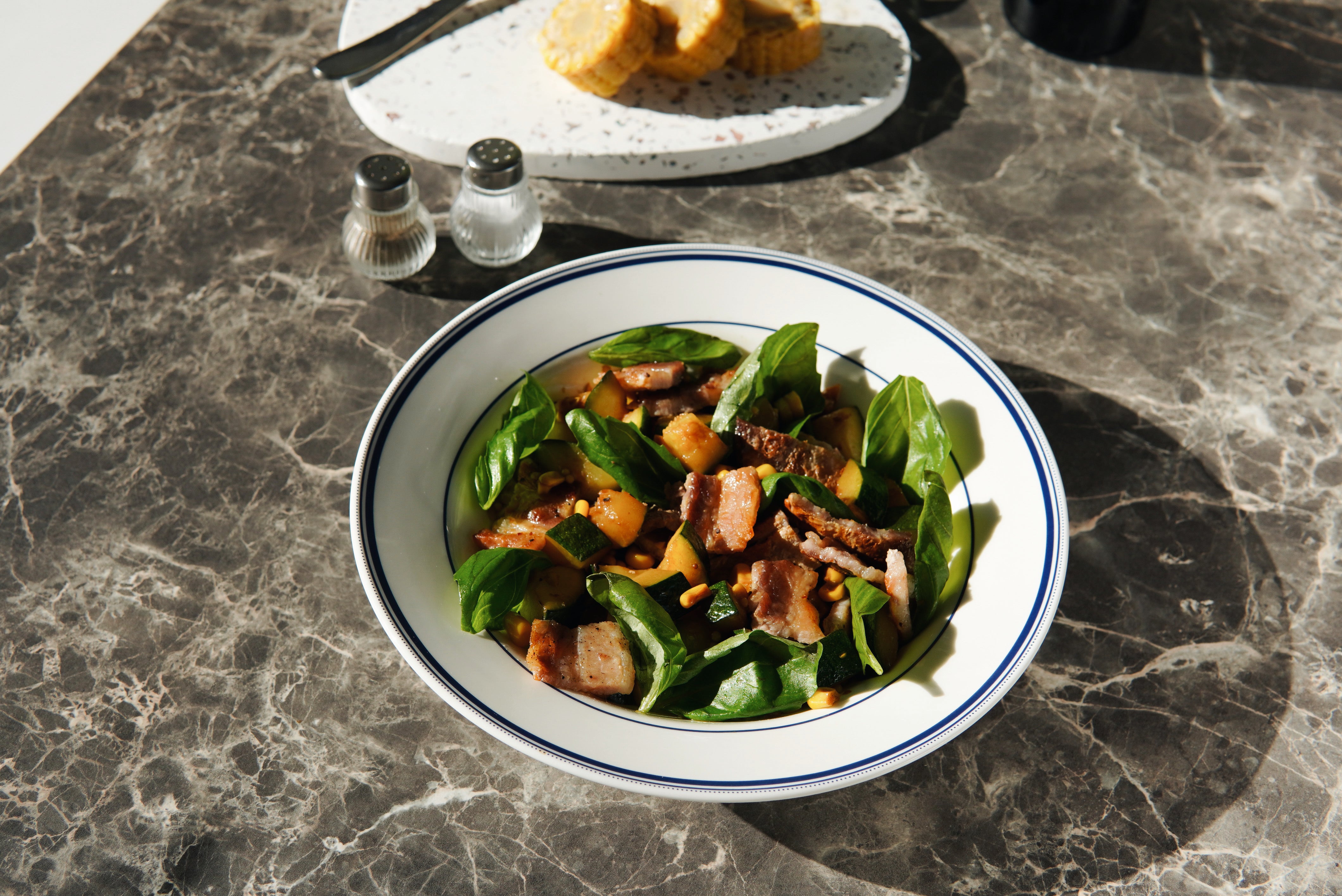 An appetizing salad featuring fresh greens, colorful vegetables, and a drizzle of high-quality Croatian olive oil. The salad is beautifully presented in a white bowl, with vibrant greens and a variety of sliced vegetables.