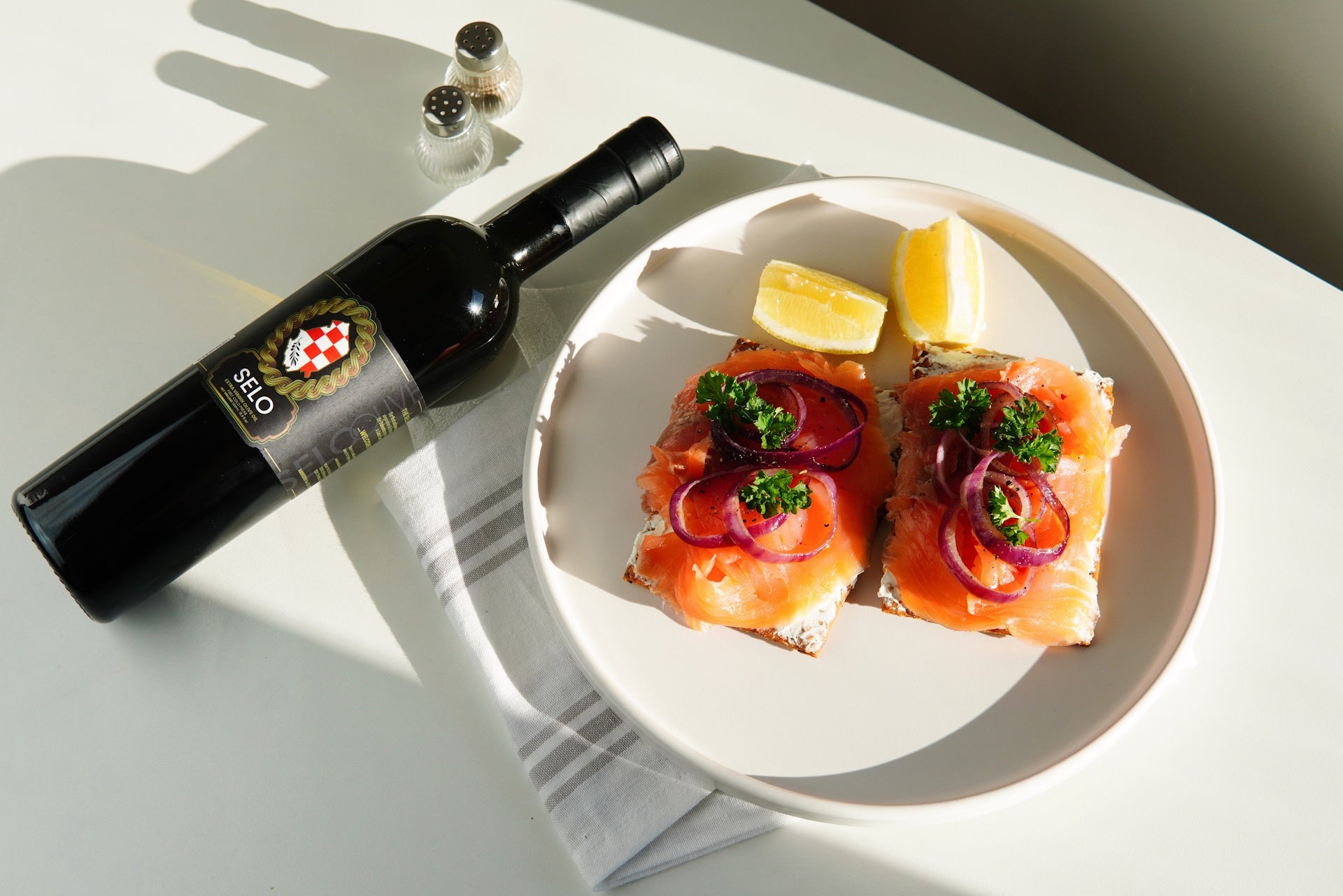 Delicate smoked salmon served with crisp crackers and tangy red onion, complemented by Croatian olive oil.