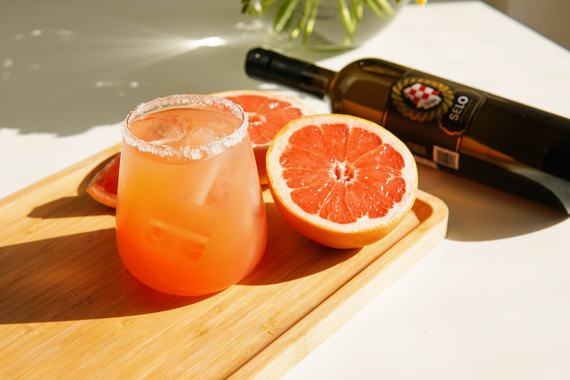 Grapefruit cocktail with a salted rim, a tantalizing mix of flavors combining the refreshing tartness of grapefruit with the savory hint of salt, perfect for summer enjoyment.