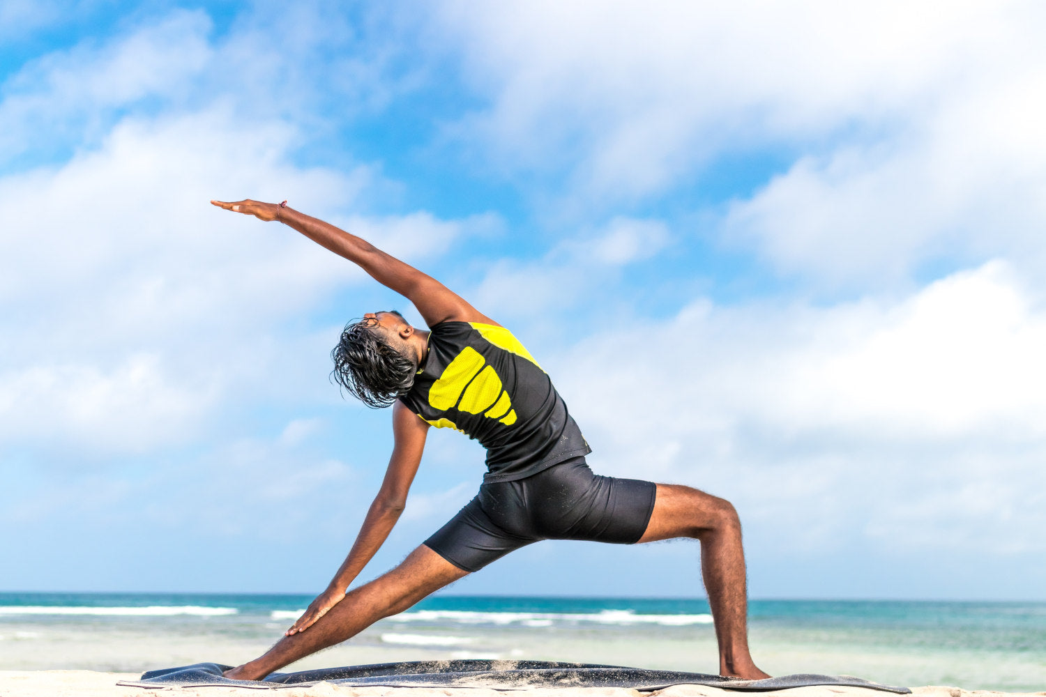 Man stretching on the beach on a sunny day