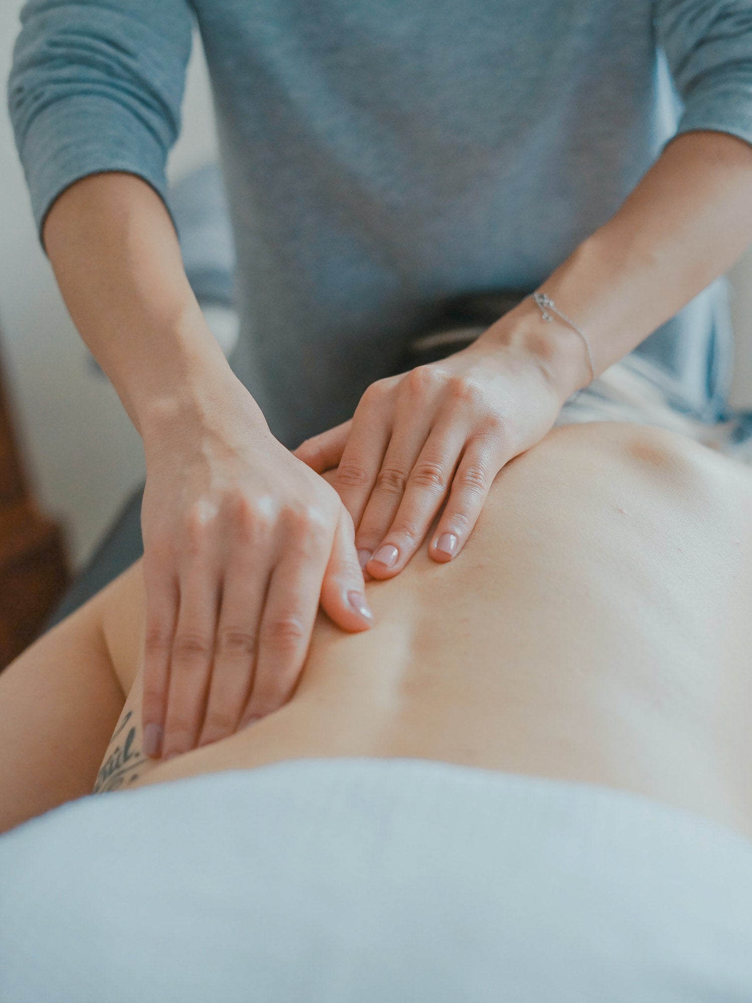 Massage therapist giving a back massage to a client